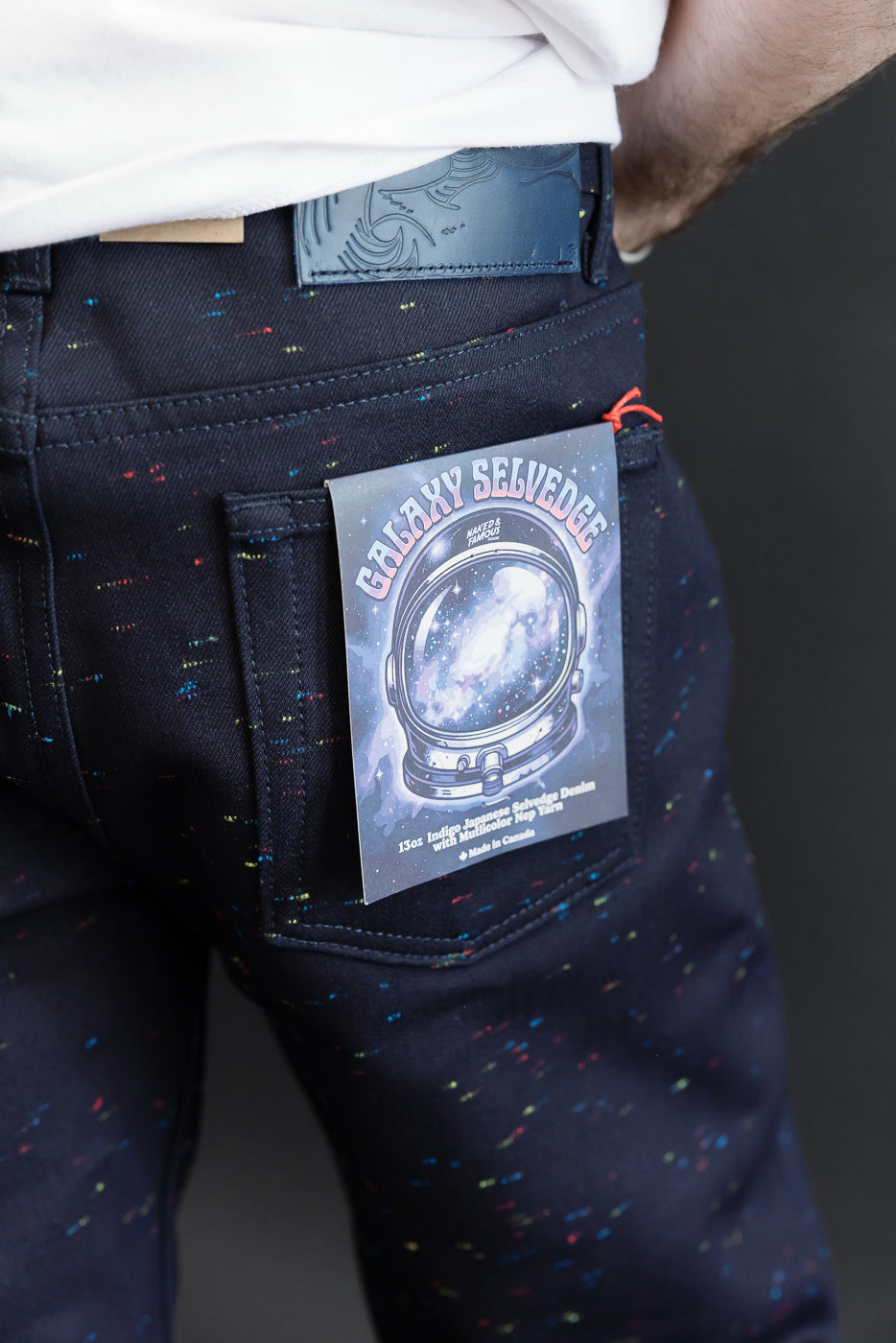 Close-up of the back pocket of male model's Galaxy Selvedge denim jeans with an astronaut tag.