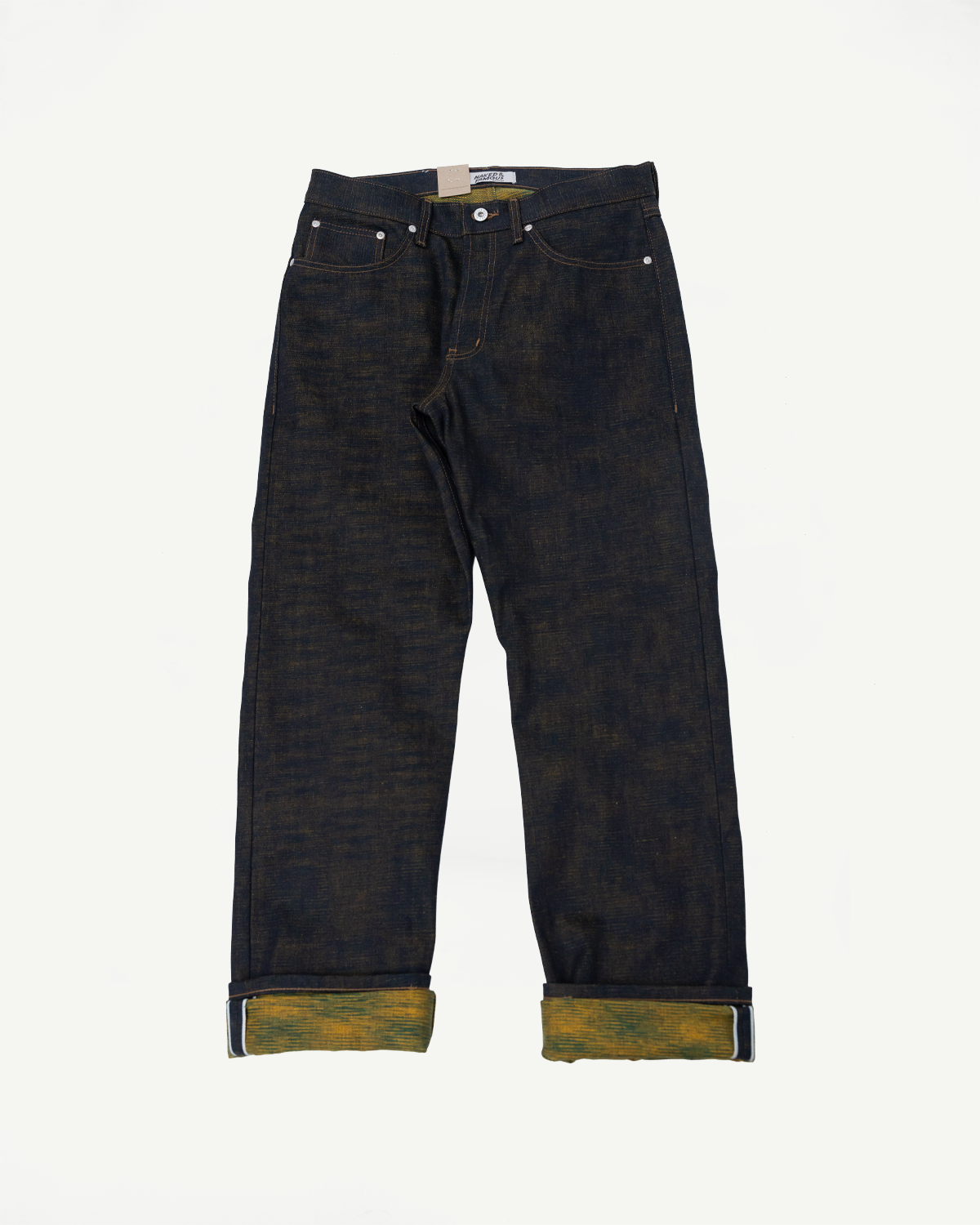 Flat lay, front view of raw selvedge denim jeans with cuffed hems showing yellow interior.