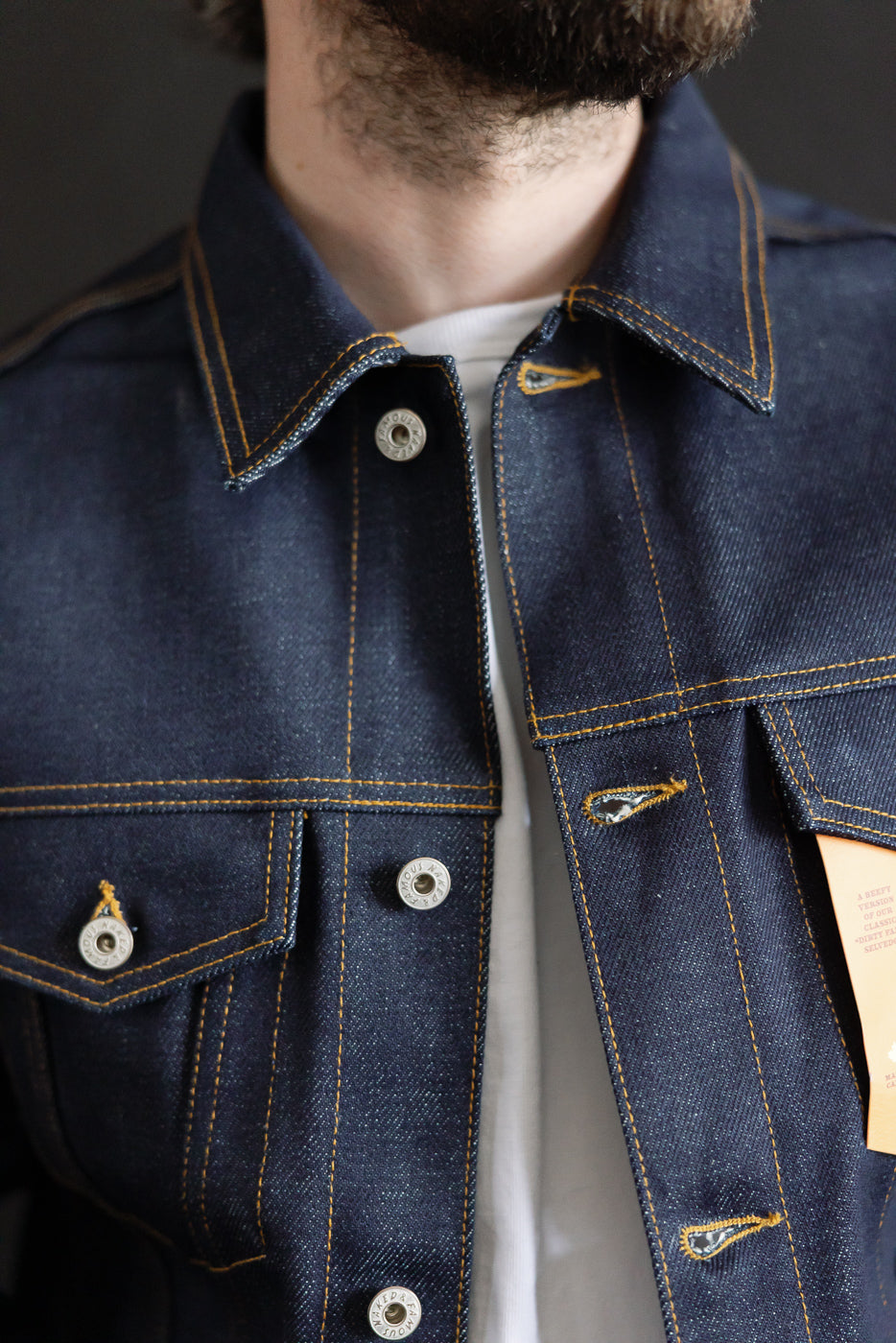 Close-up front view of Naked & Famous 20oz Dirty Elephant selvedge denim jacket on male model, 5'9