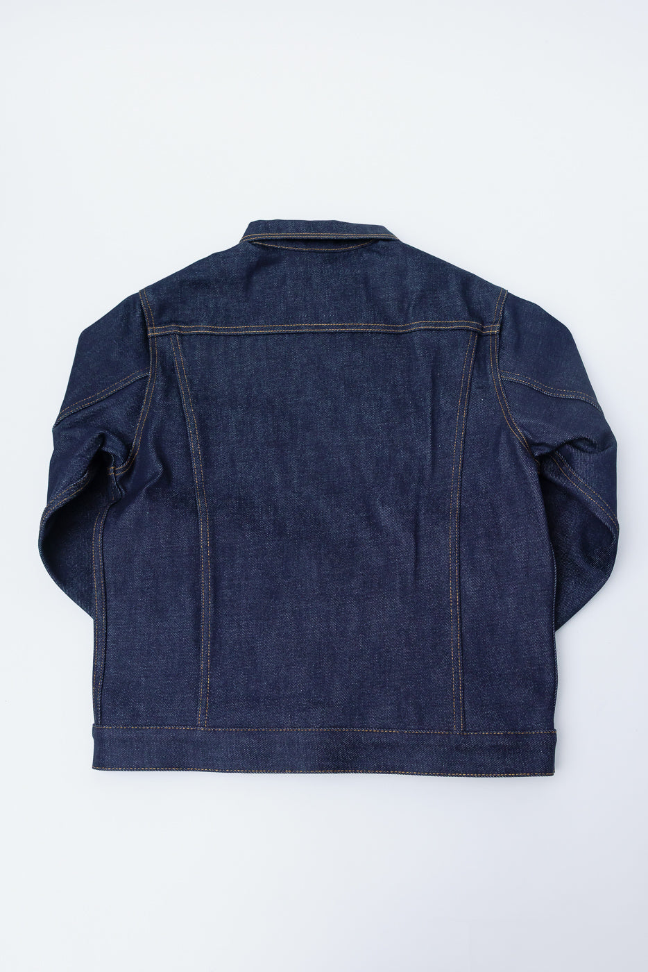 Flat lay of Naked & Famous 20oz Dirty Elephant 14oz selvedge denim jacket, back view.