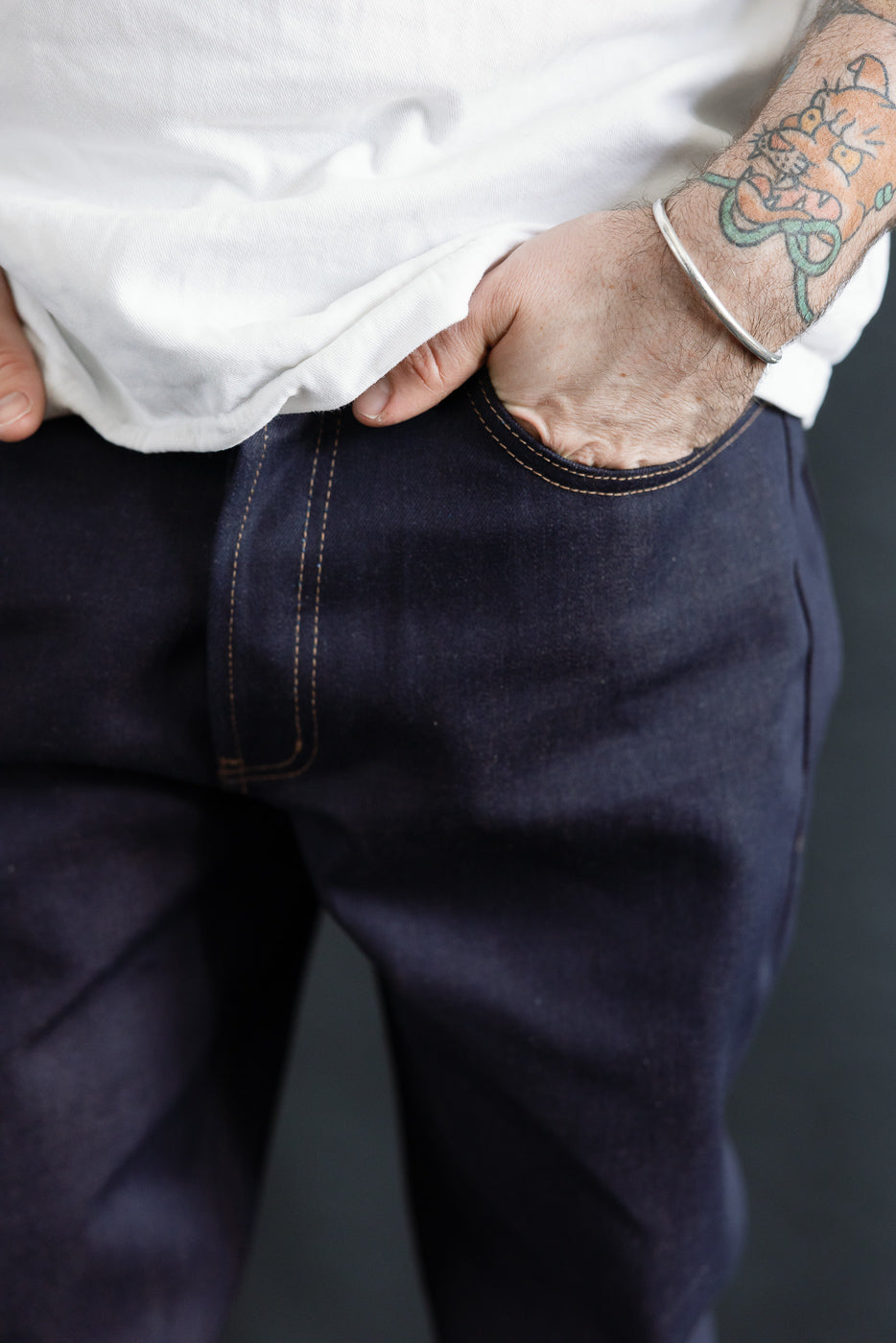 Close-up front view of men's selvedge jeans, modeled by a male, 5'9