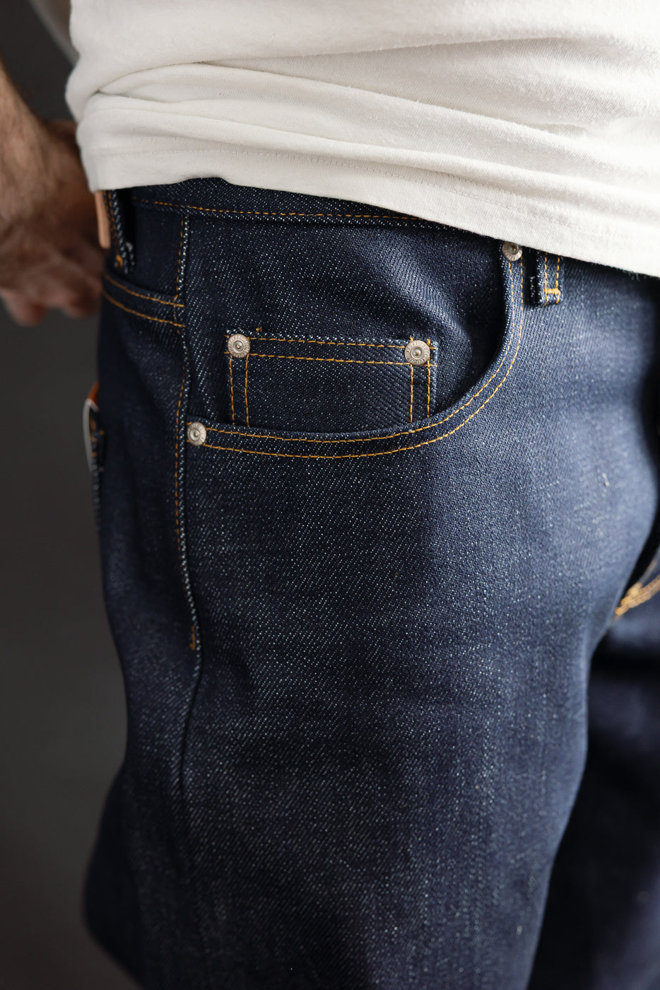 Close-up of front pocket and upper side seam of Naked & Famous Dirty Elephant 14oz selvedge jeans on male model, 5'9