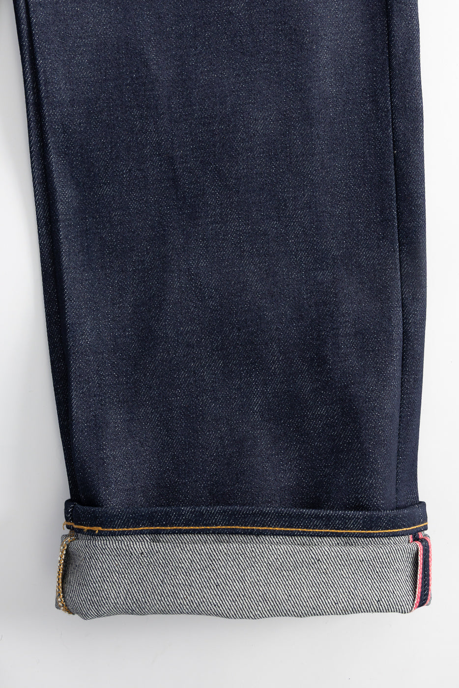 Close-up of Naked & Famous Dirty Elephant 14oz selvedge denim cuff, hem, and fabric texture, front leg.