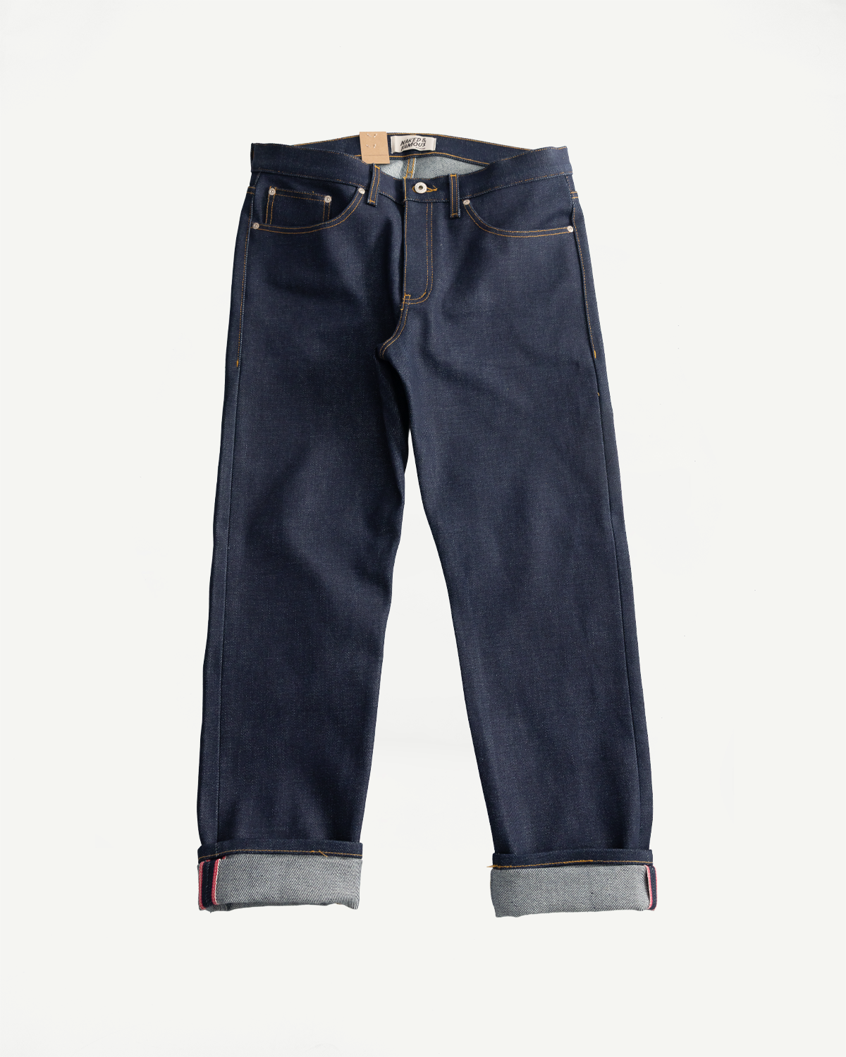 Flat lay front view of Naked & Famous Dirty Elephant 14oz selvedge denim jeans, cuffed hem, Dant.