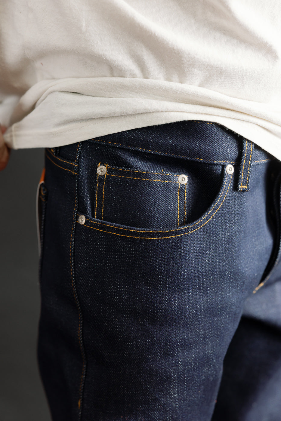 Close-up of men's raw selvedge denim jeans front pocket, male model 5'9
