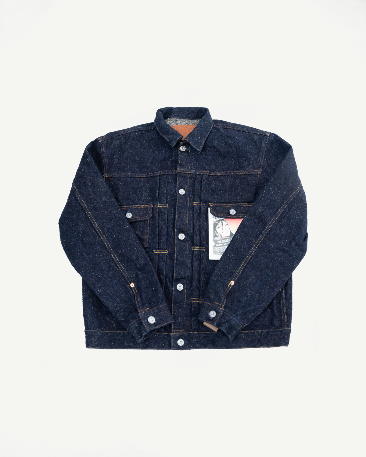 Flat lay front view of raw selvedge denim jacket, button front, visible tag, classic collar.