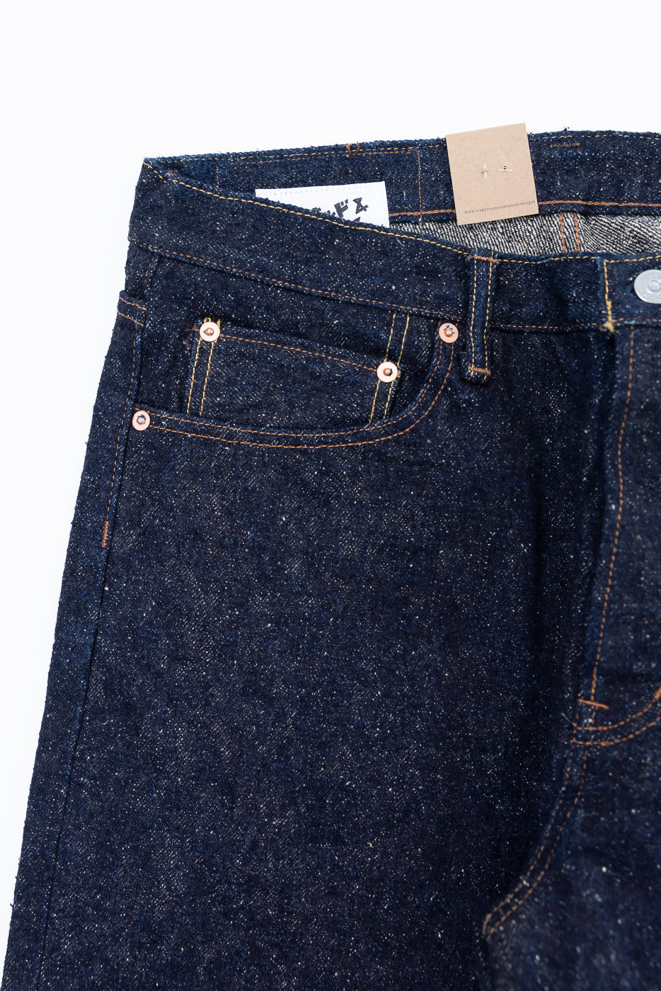 Close-up front view of Naked & Famous Genseki selvedge denim jeans, showing pocket, rivets, and fabric texture.