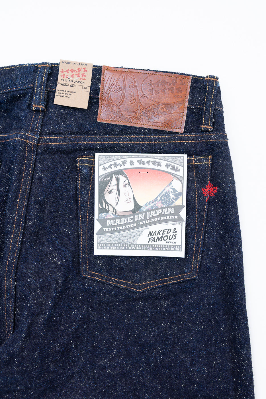 Close-up of Naked & Famous MIJ16 Genseki Selvedge Strong Guy jeans back, showing pocket, leather patch, and tags.