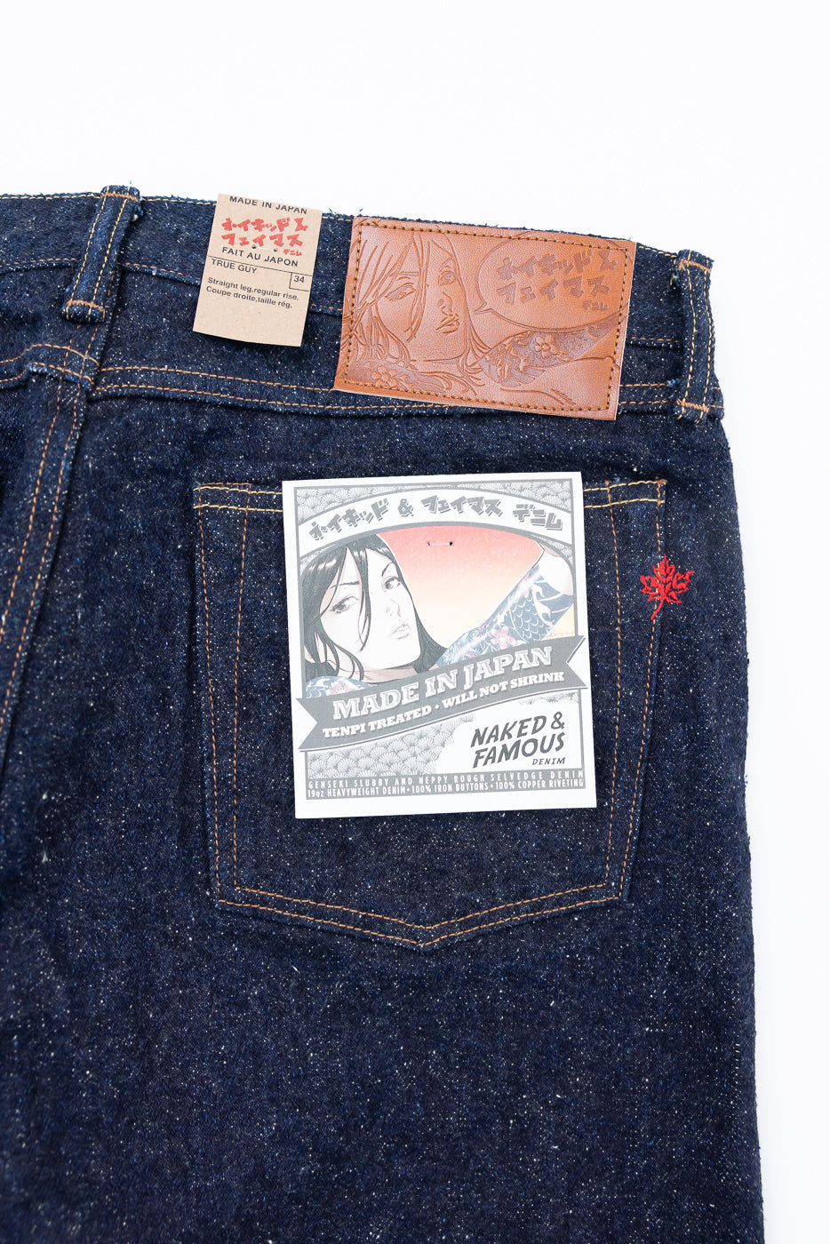 Close-up of Naked & Famous Genseki Selvedge denim jeans back, showing leather patch, size tag, and rear pocket details at Dant store.