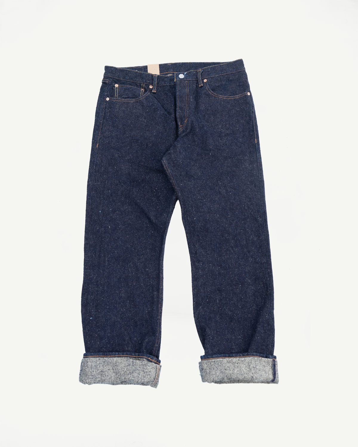 Flat lay front view of Naked & Famous Genseki Selvedge jeans, raw denim, cuffed hem, classic five-pocket style.