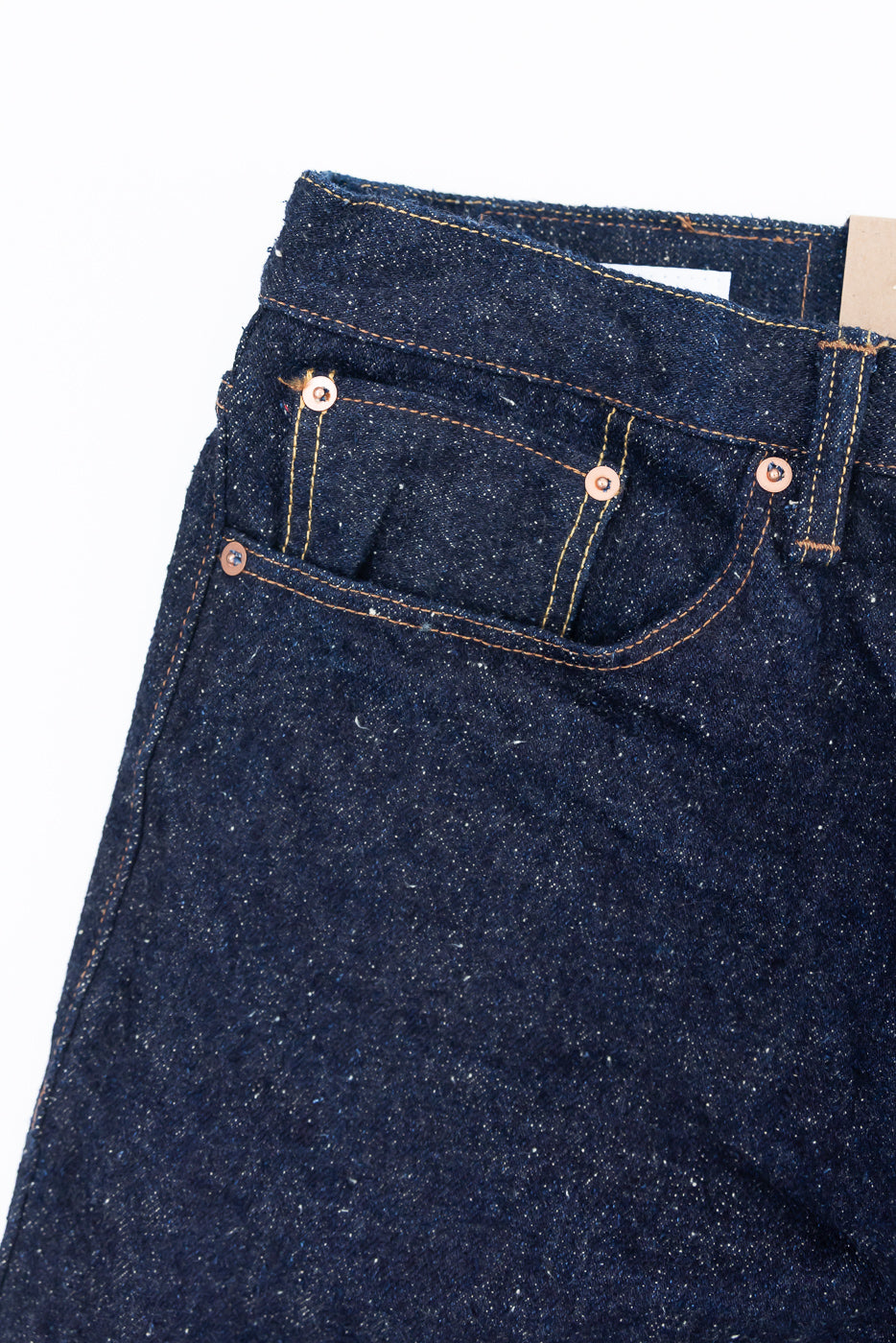 Close-up of Naked & Famous Genseki Selvedge jeans, front left pocket, visible texture and rivets
