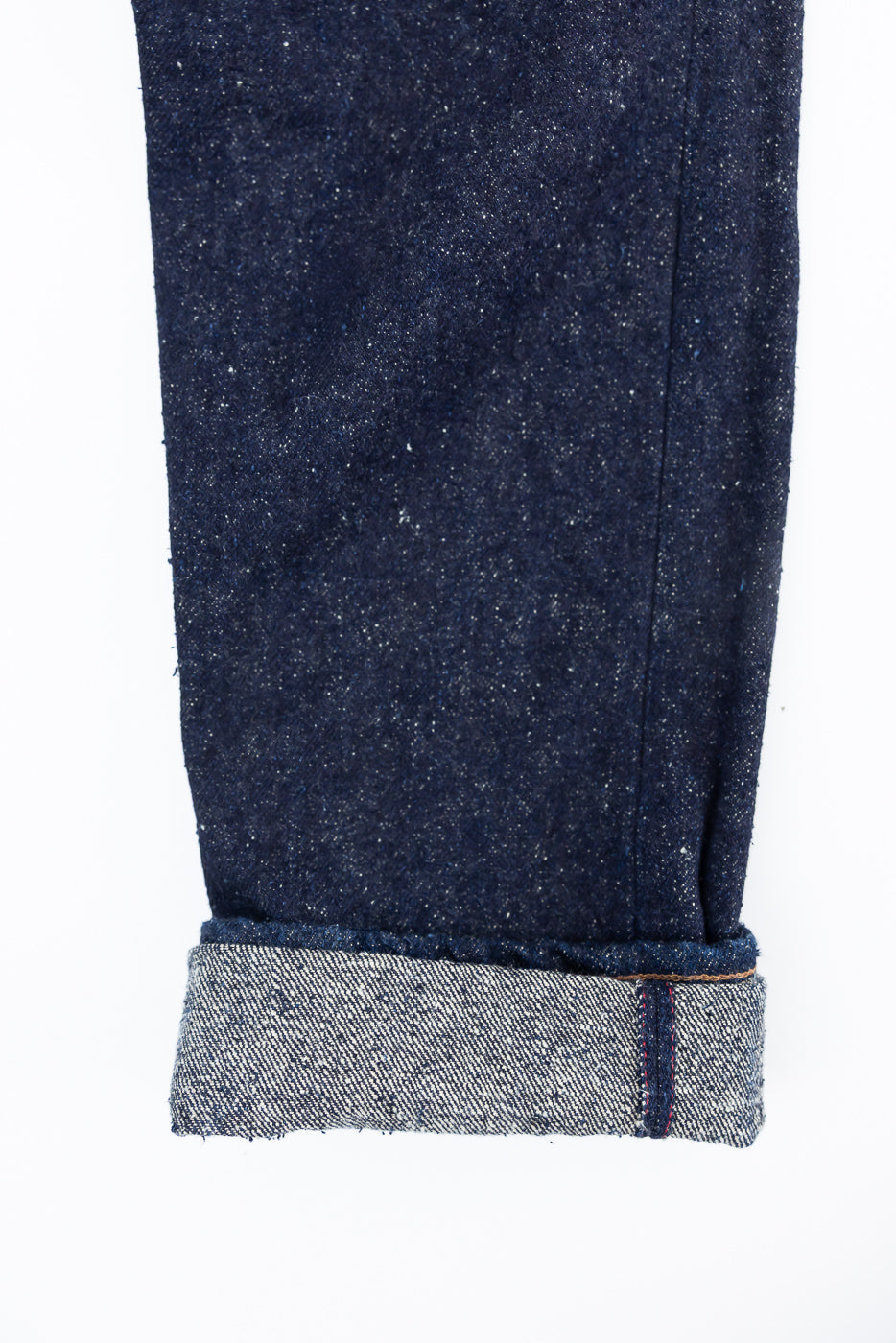 Close-up of Naked & Famous Genseki Selvedge denim cuff, showing selvedge edge and fabric texture.