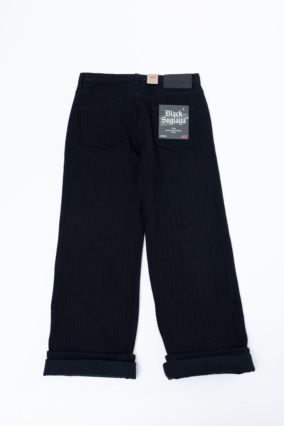 Front view flat lay of black wide-leg corduroy trousers with cuffed hems.