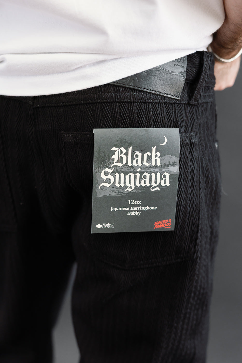 Close-up of the back right pocket of black 12oz Japanese herringbone denim on a male model.