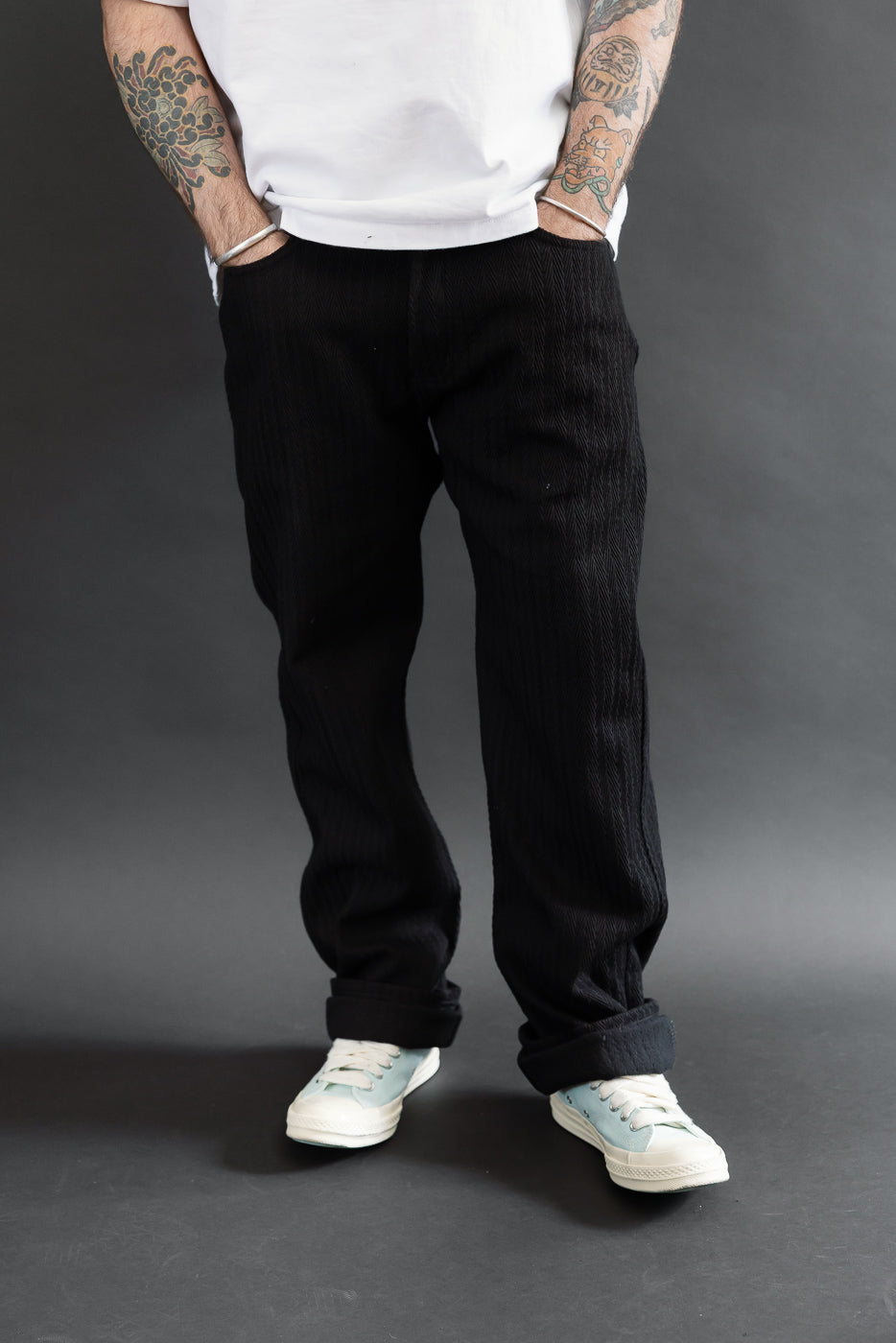 Full body view from the front of black textured trousers worn by a 5'9