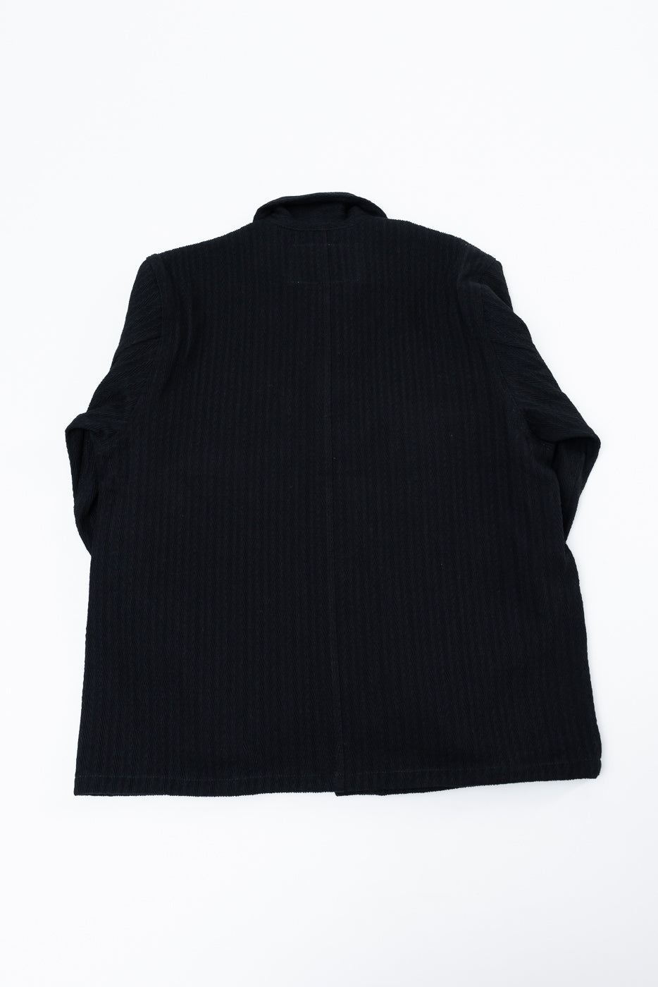 Flat lay, back view of a black textured corduroy jacket.