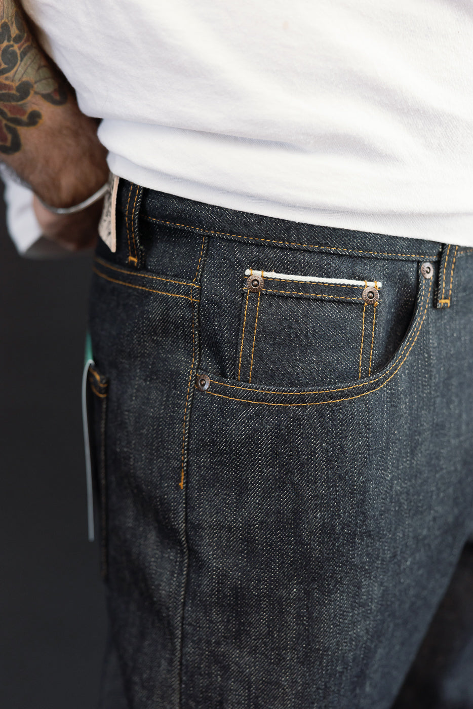 Close-up back view of dark selvedge denim jeans on male model, 5'9