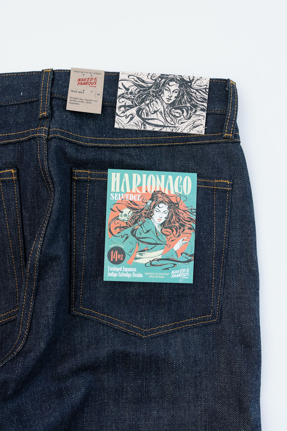 Close-up of back pocket showcasing Marionago selvedge denim tag, 14oz unsinged Japanese indigo, with detailed stitching.