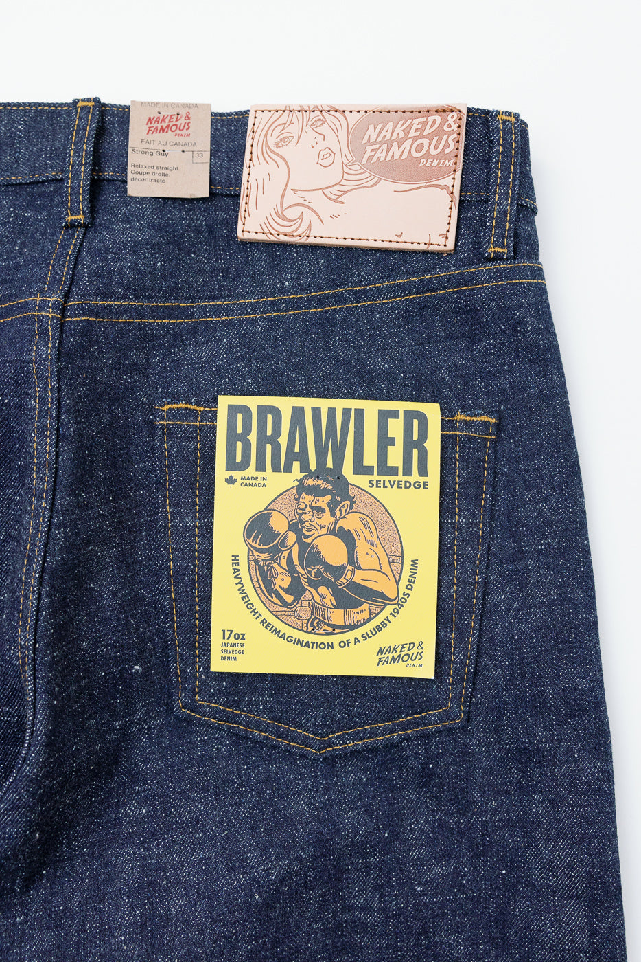 Close-up of back pocket showcasing Brawler selvedge denim tag, 17oz Japanese fabric, and brand labels