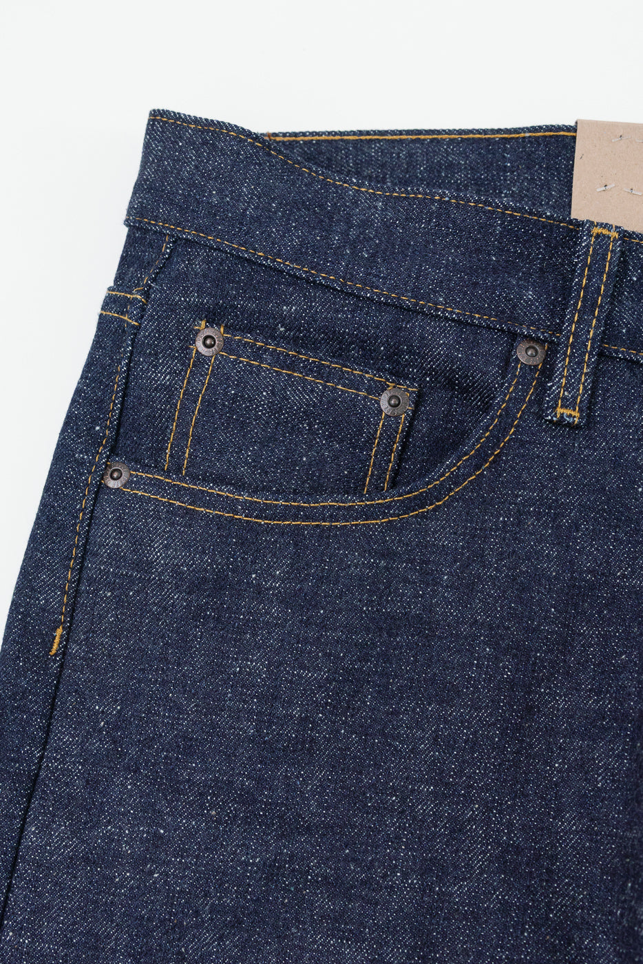 Close-up of front denim jeans pocket with yellow stitching and metal rivets, showcasing fabric texture.