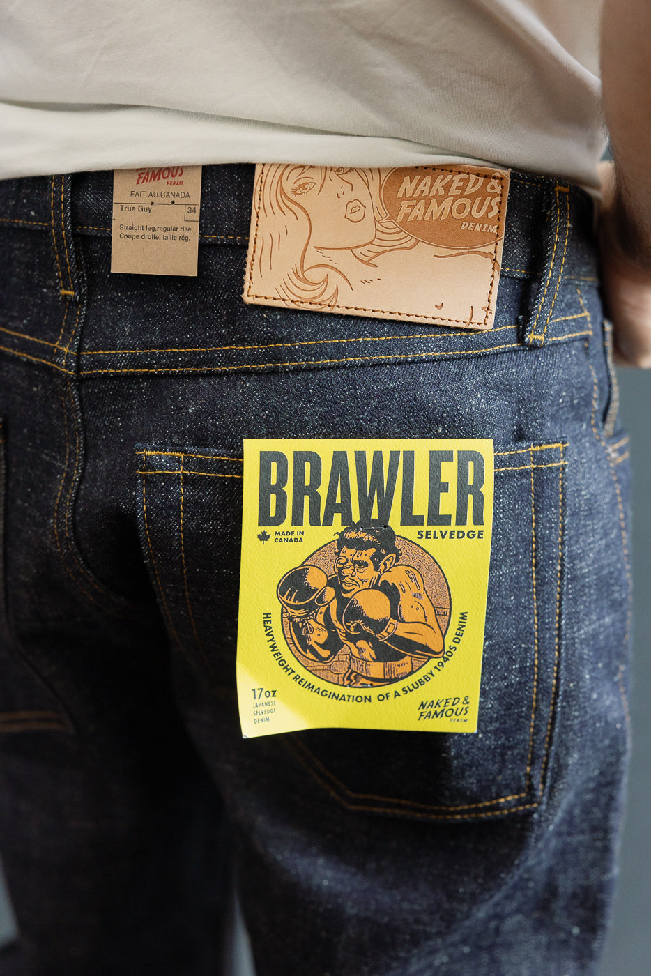Close-up of back pocket showing Brawler Selvedge jeans tag, 17oz Japanese denim, male model 5'9