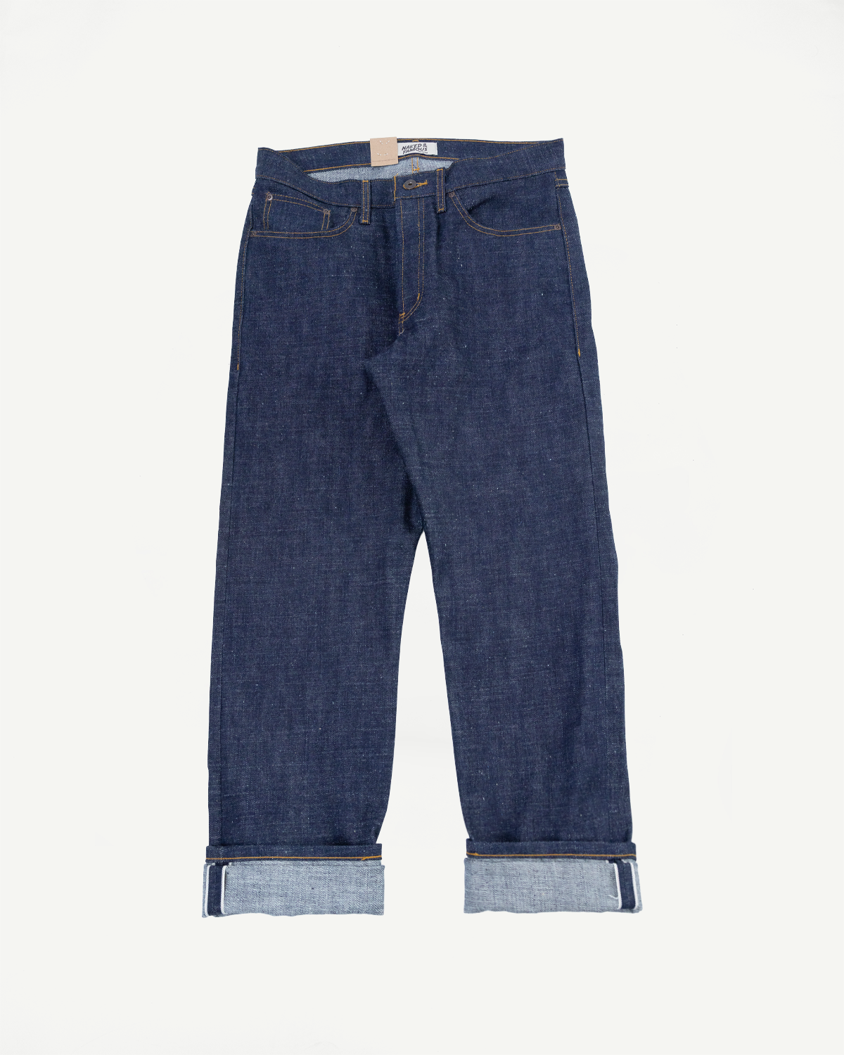 Front flat lay of raw selvedge denim jeans with cuffed hems, visible stitching, and brand tag