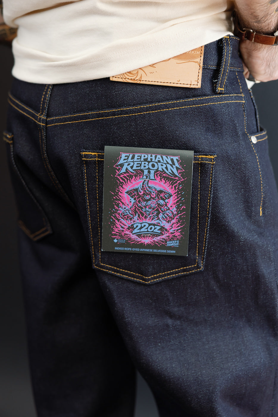 Close-up rear view of dark indigo 22oz selvedge denim jeans on a male model, 5'9
