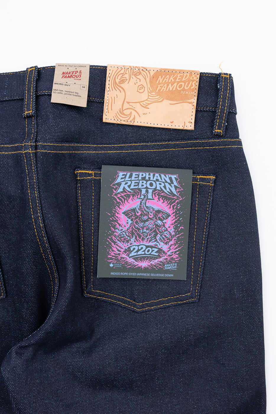 Close-up back view of Naked & Famous Denim jeans showing the back pocket with an Elephant Reborn II tag.