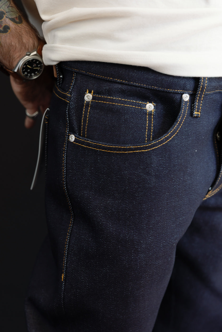 Close-up side view of dark indigo selvedge denim jeans on a 5'9