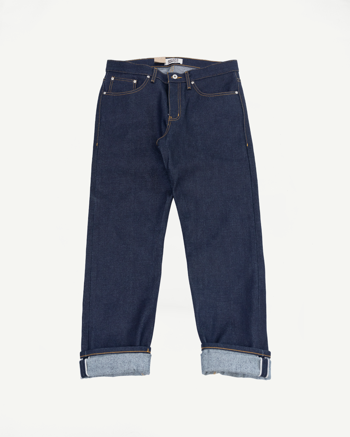 Full body front view of dark indigo selvedge denim jeans with cuffed hems.
