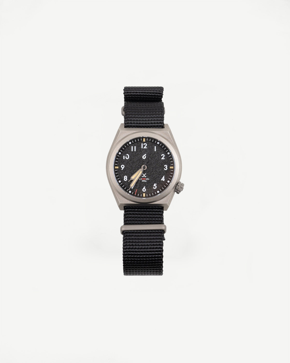 Flat lay front view of black field watch with nylon strap and textured black dial.