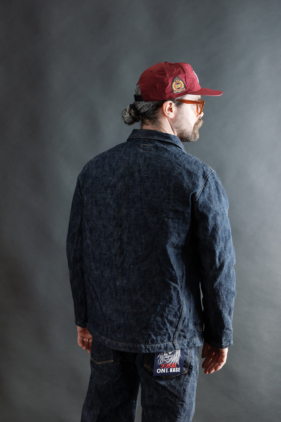 Male model 5'9 165lbs athletic build wearing denim selvedge jacket, back view, full body.