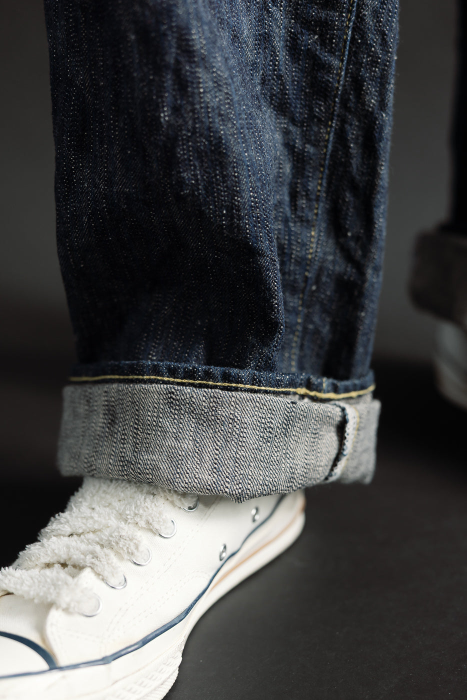 Close-up of ONI Kase Denim selvedge jeans cuff, front leg with visible fabric texture on male model, 5'9