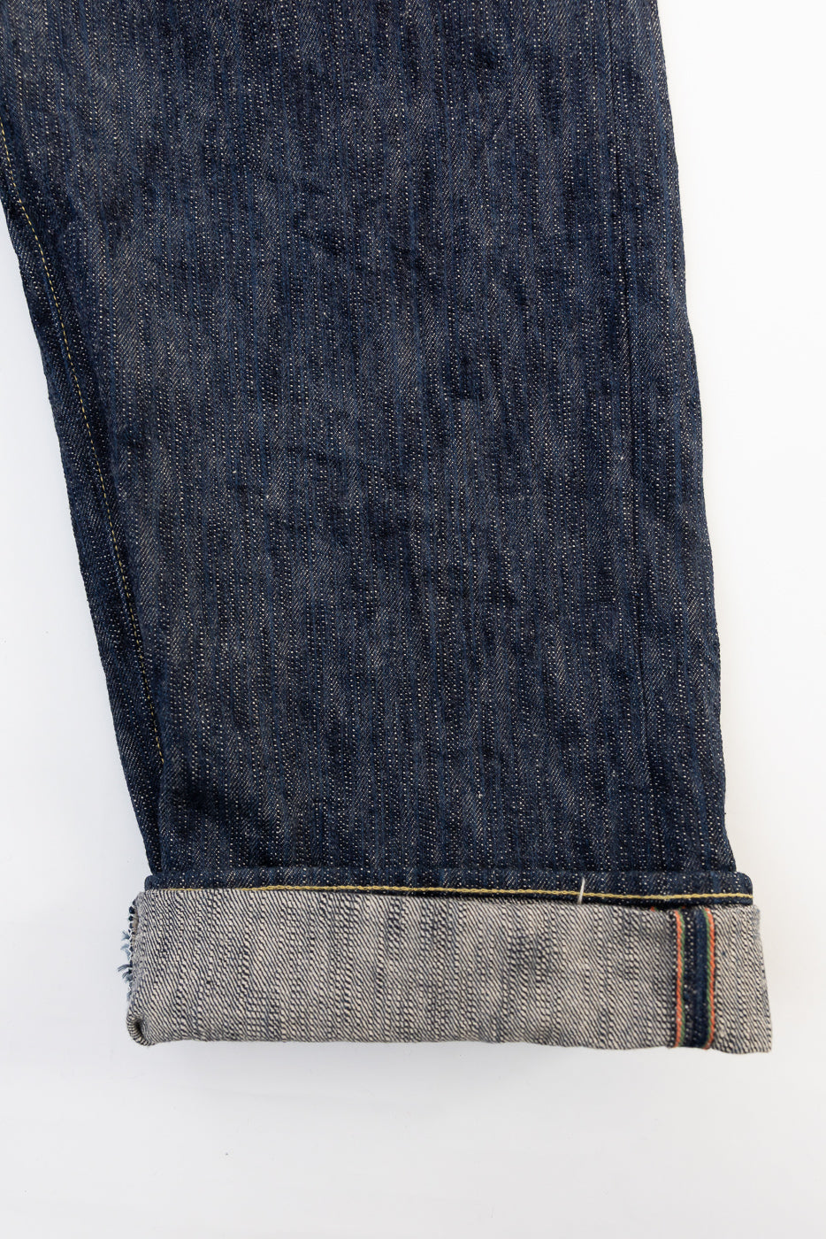 Close-up of ONI Kase Denim selvedge jeans leg, cuffed hem, right side, showing selvedge edge.