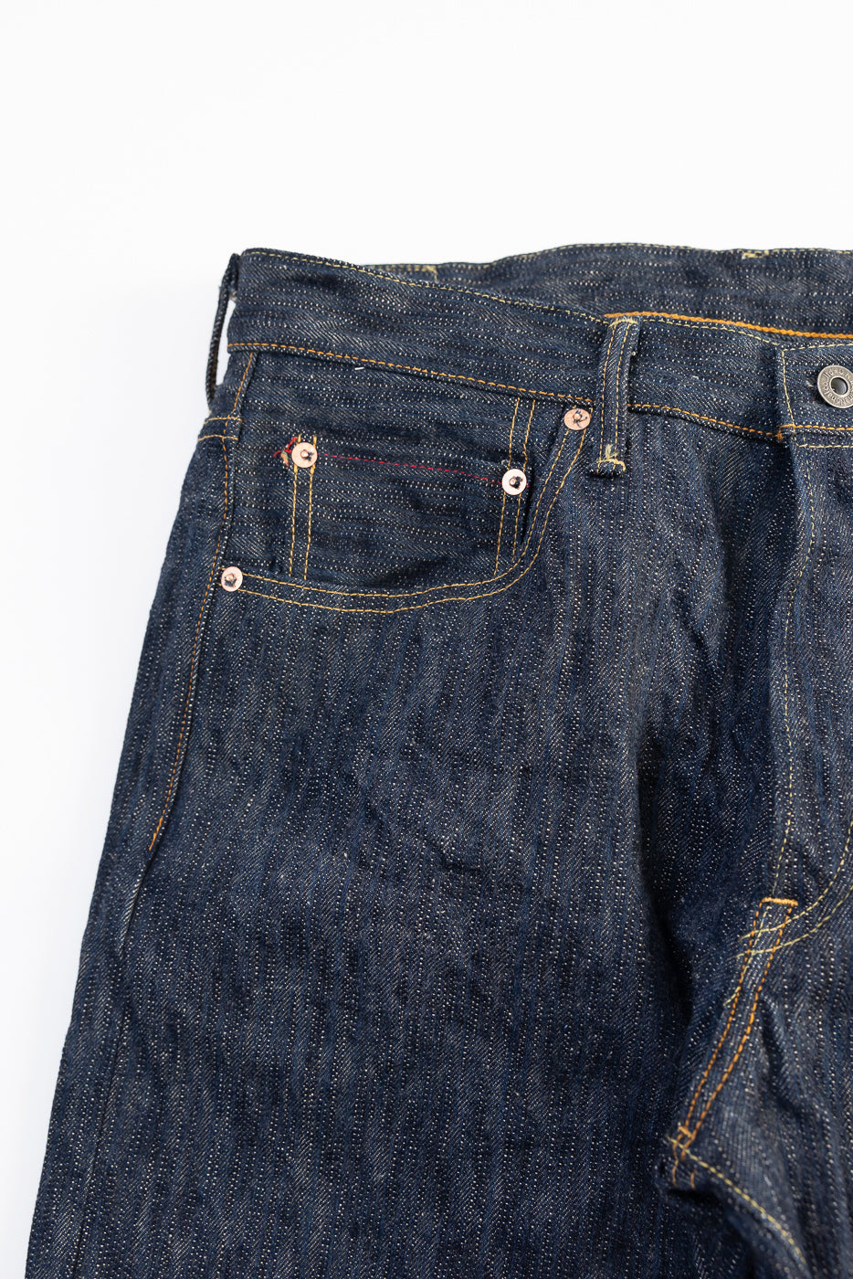 Close-up of front left waist and pocket of ONI 200 KAS 16oz Kase selvedge denim jeans, highlighting texture, rivets, and stitching detail.
