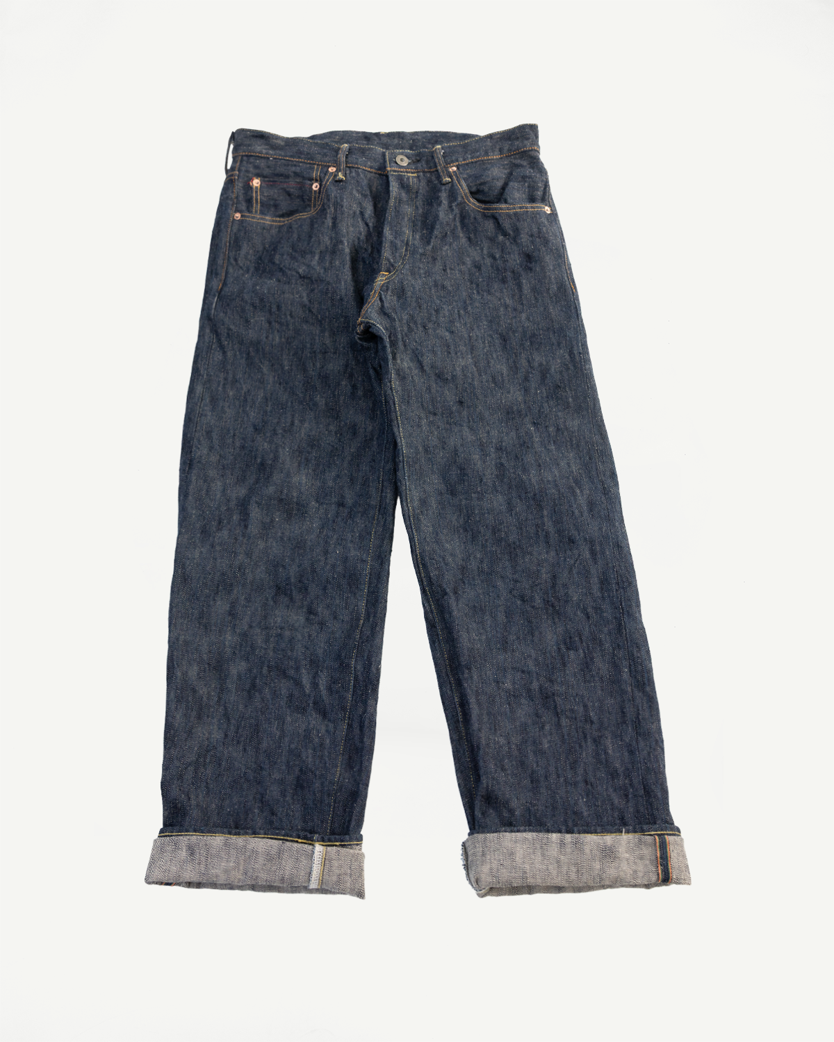 Flat lay front view of wide straight selvedge denim jeans, cuffed hem, showing full garment.