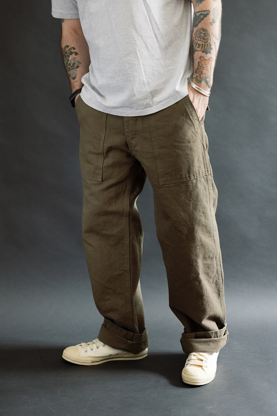 The ONI Denim 207-HOX-OLB pants feature a wide straight cut with large patch pockets, cuffed hems, and a relaxed fit in olive khaki, styled with casual T-shirt and sneakers.