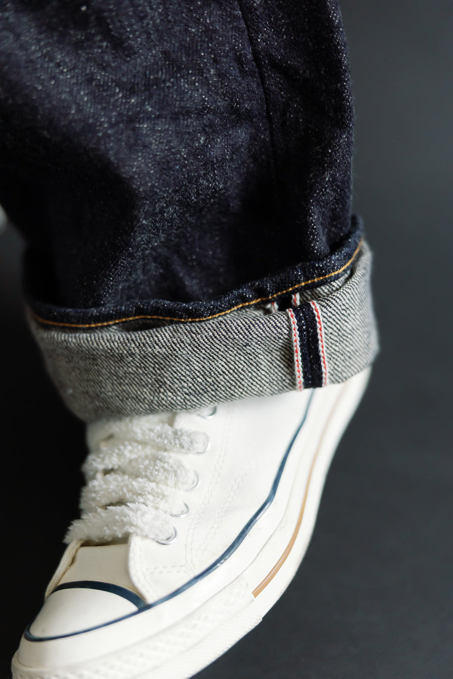 Close-up of selvedge cuff and raw denim texture on Oni 20oz Secret Denim jeans, side view.