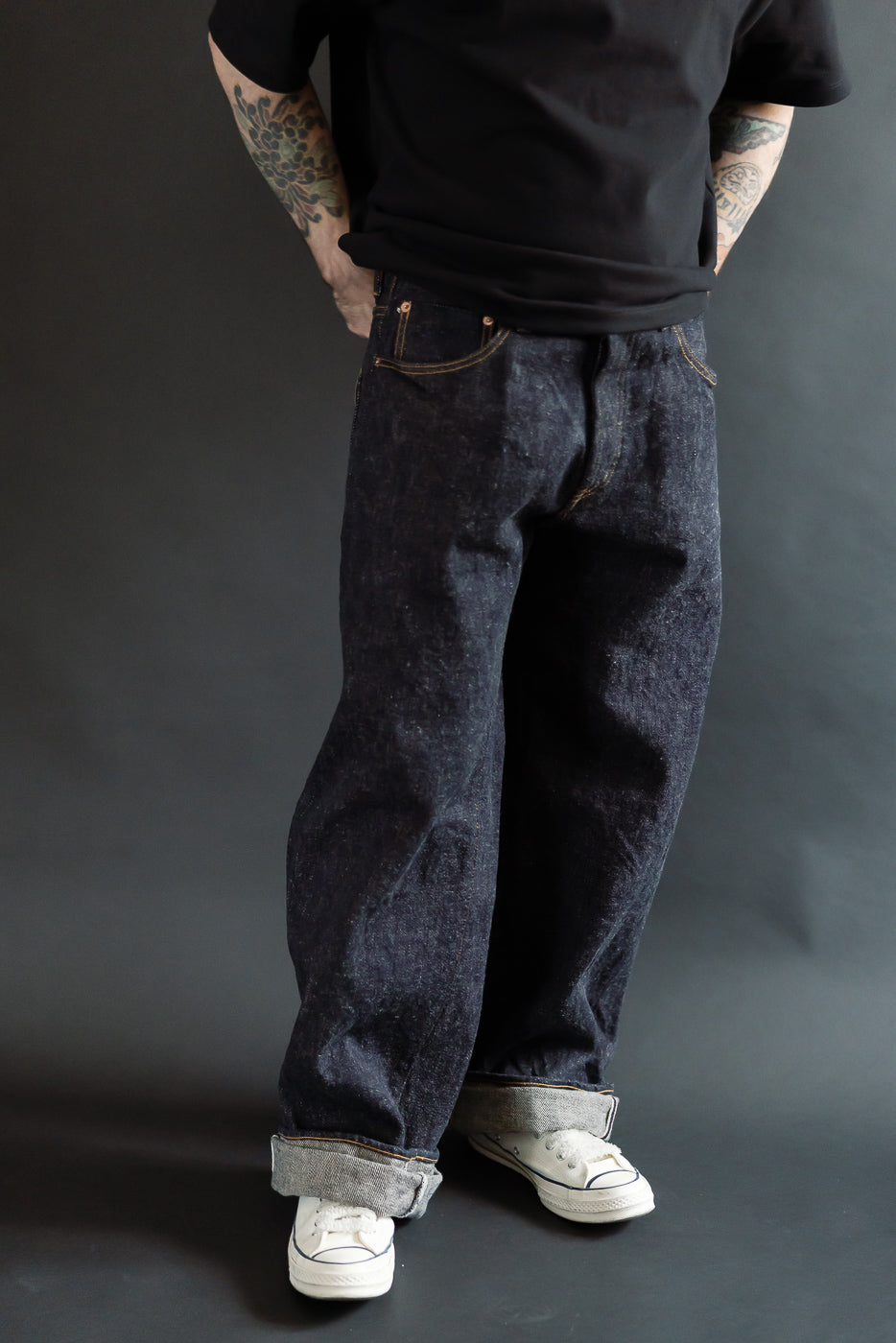 Front view full-body of 5'9, 165lb athletic male model in wide straight fit dark indigo selvedge jeans at Dant.