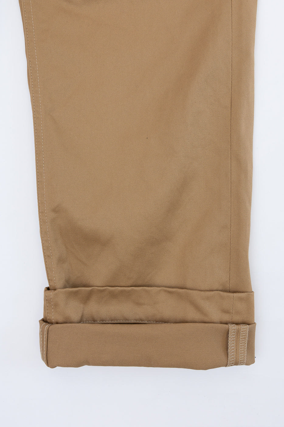 Tan chino pants close-up, front view, cuffed hem with visible stitching detail