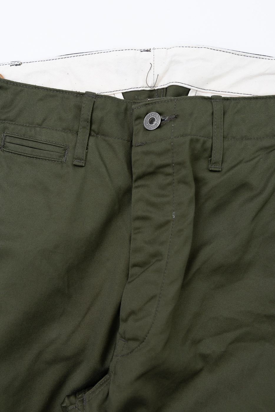 Close-up front view of olive green men's casual pants showing button fly, belt loops, and white interior lining.