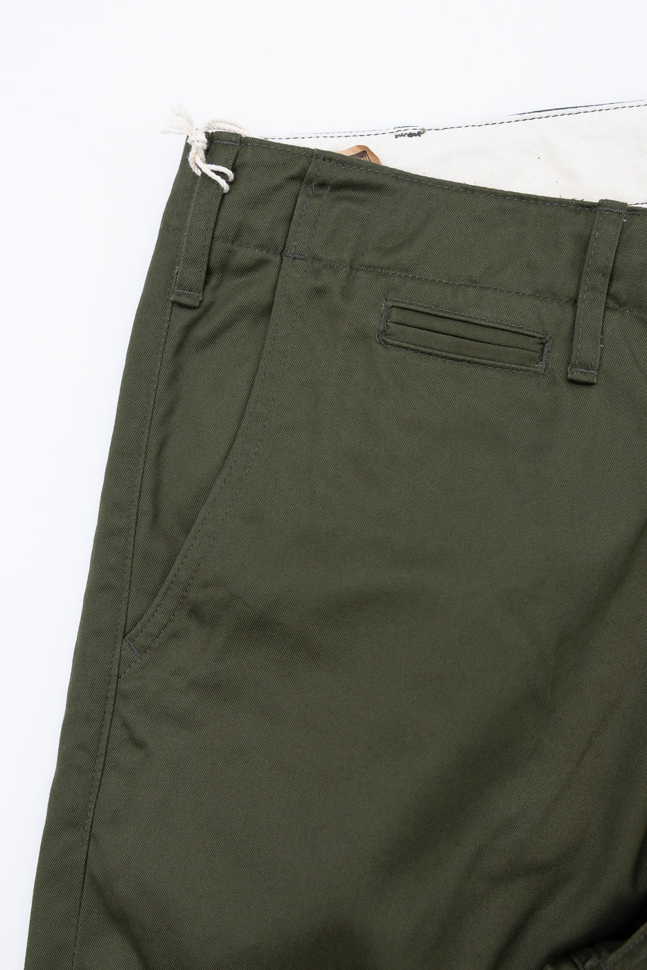 Close-up front view of olive green casual pants, showing waistband, front pocket, and fabric texture