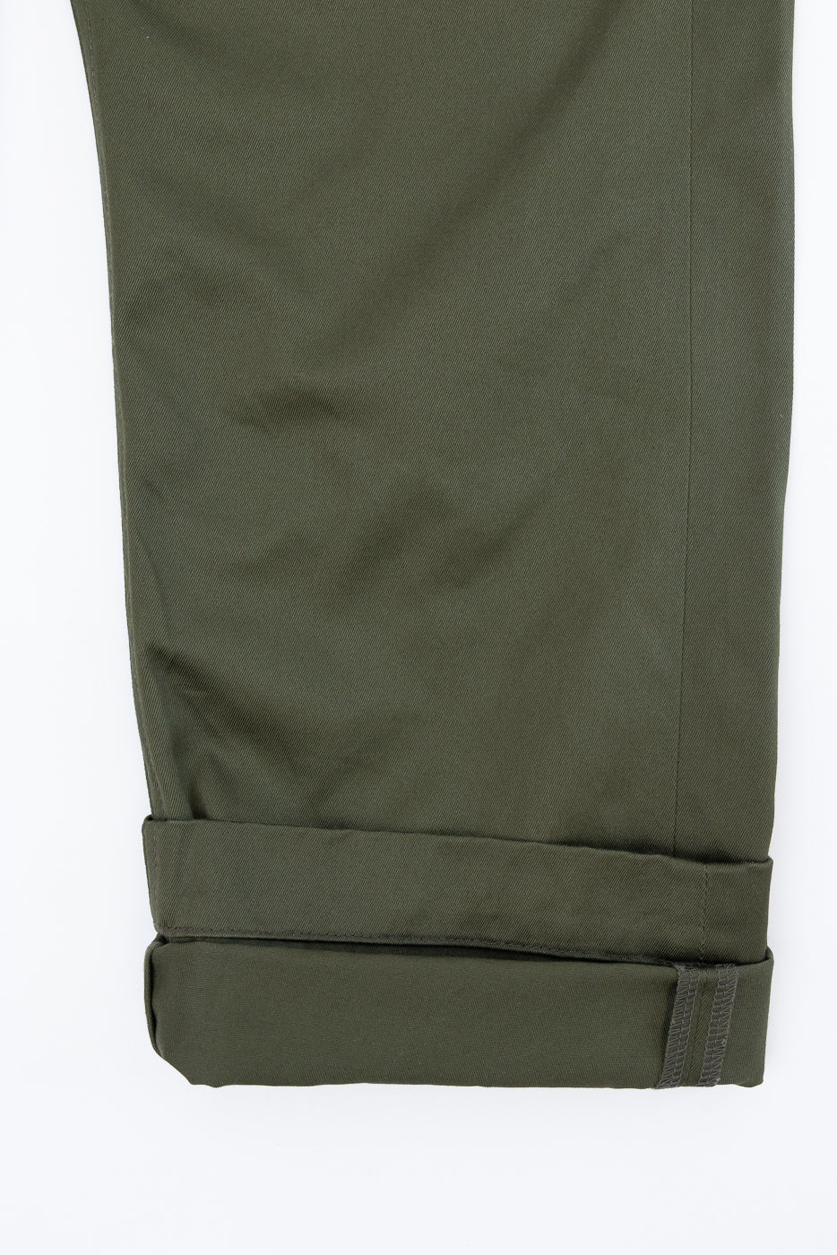 Olive green pants close-up, front view, cuffed hem with visible stitching detail