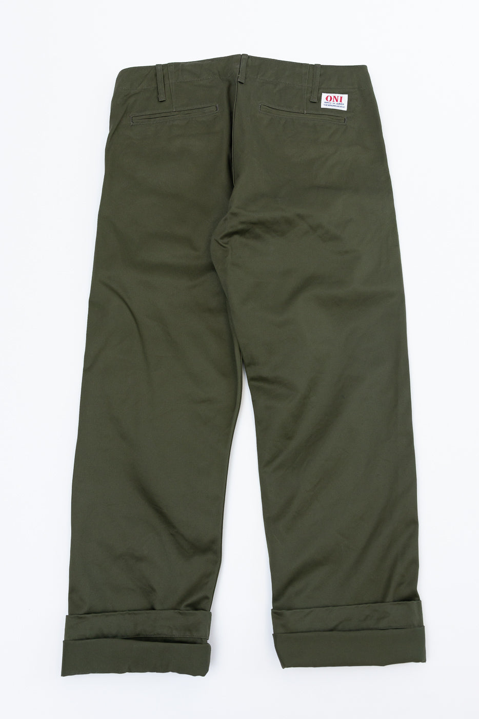 Flat lay back view of olive green chinos with cuffed hems, rear pockets, and ONI brand tag