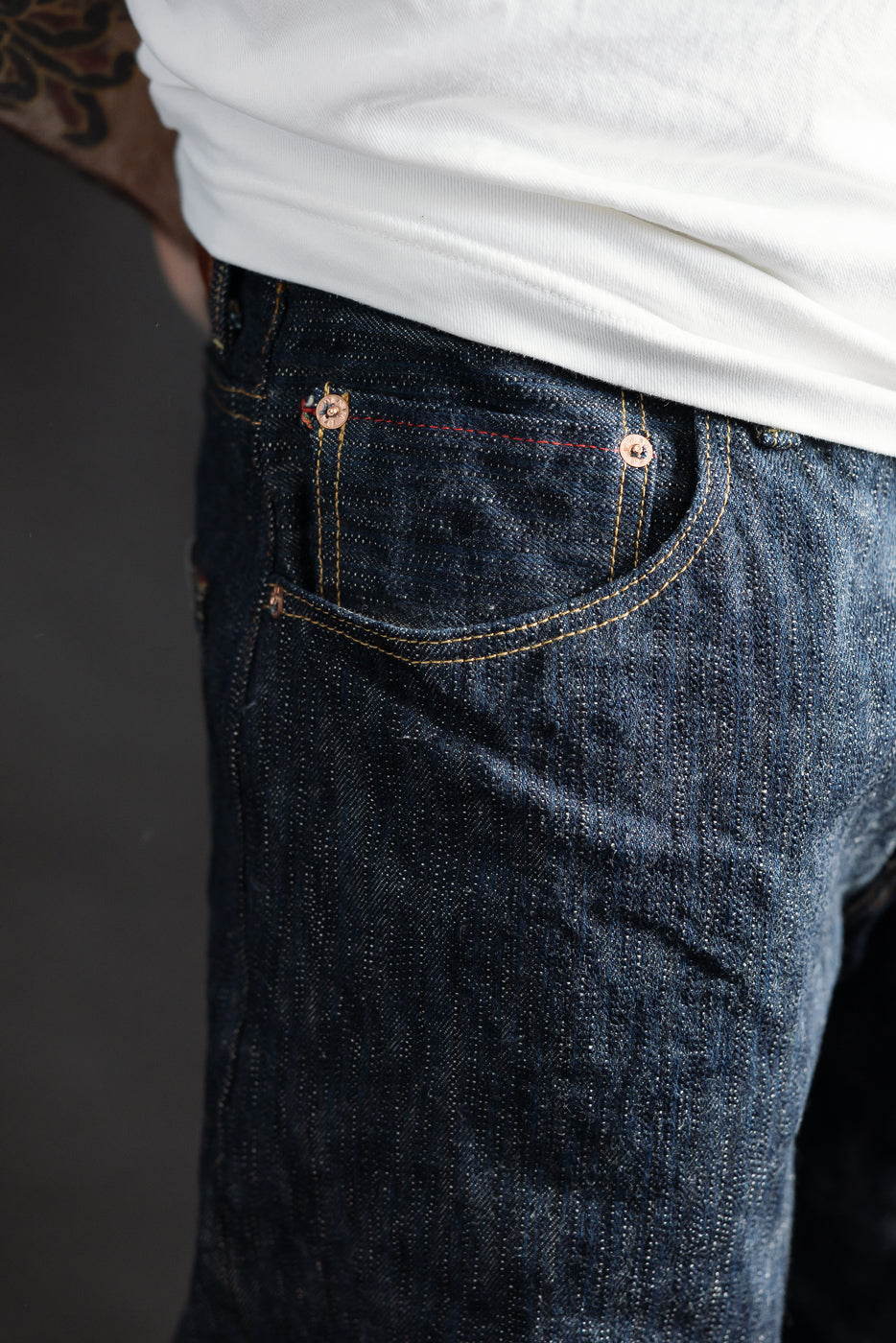 Close-up of front left side selvedge denim jeans pocket, worn by male model 5'9