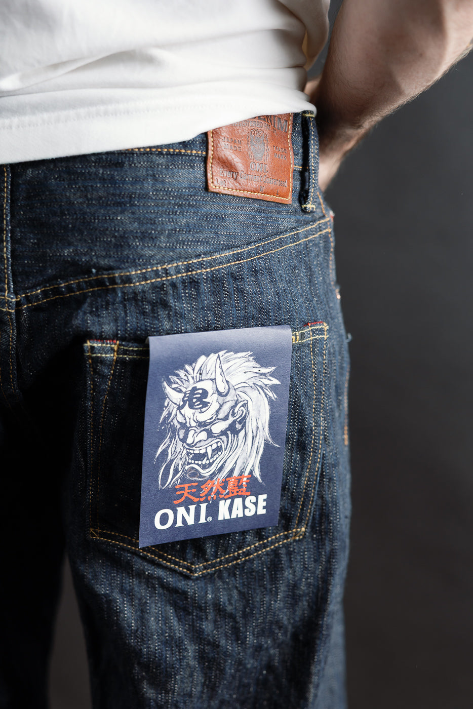 Close-up of back right pocket and leather patch of ONI Kase selvedge jeans on male model, 5'9