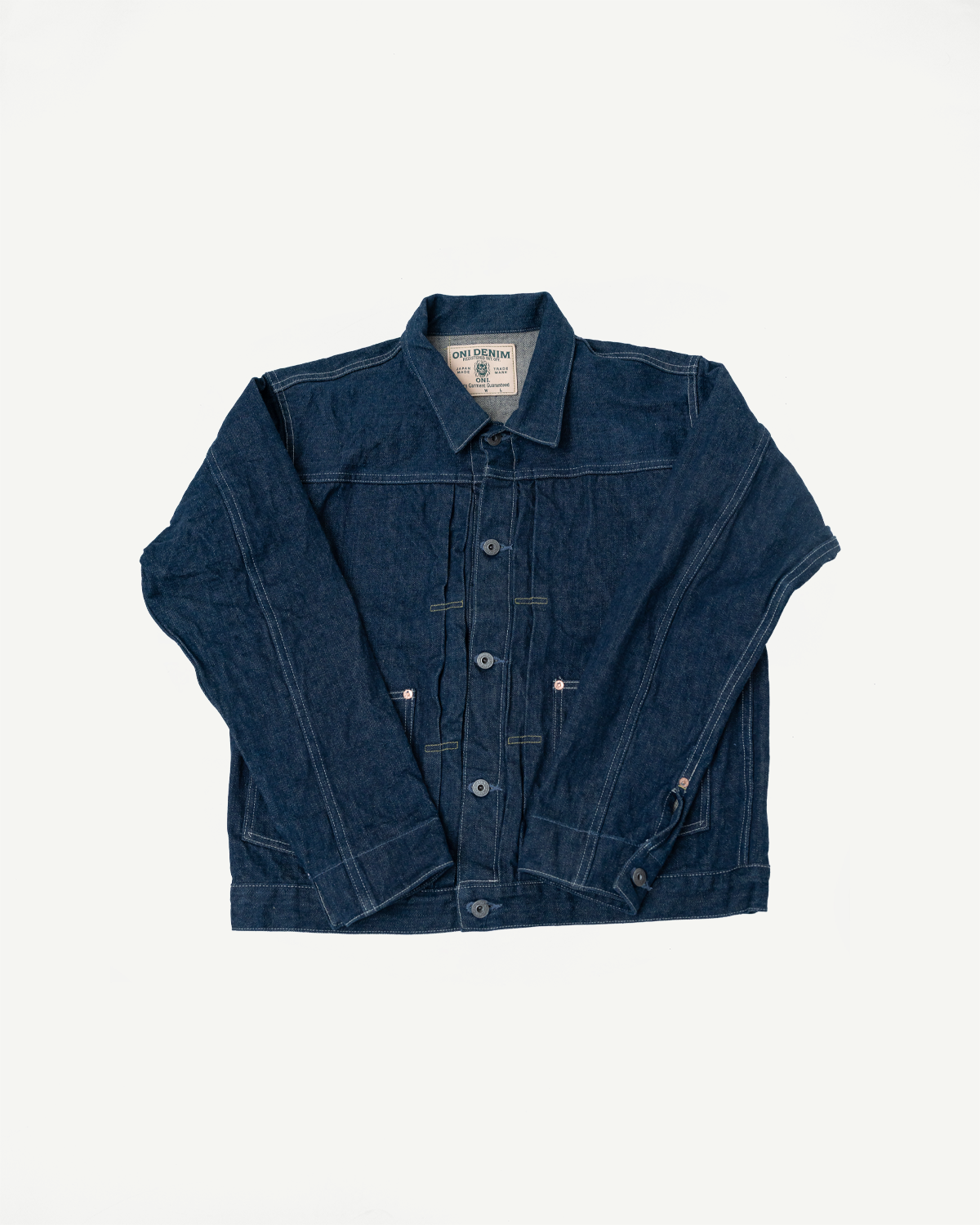 Flat lay front view of 15oz selvedge denim jacket showing buttons, collar, and chest tag detail.