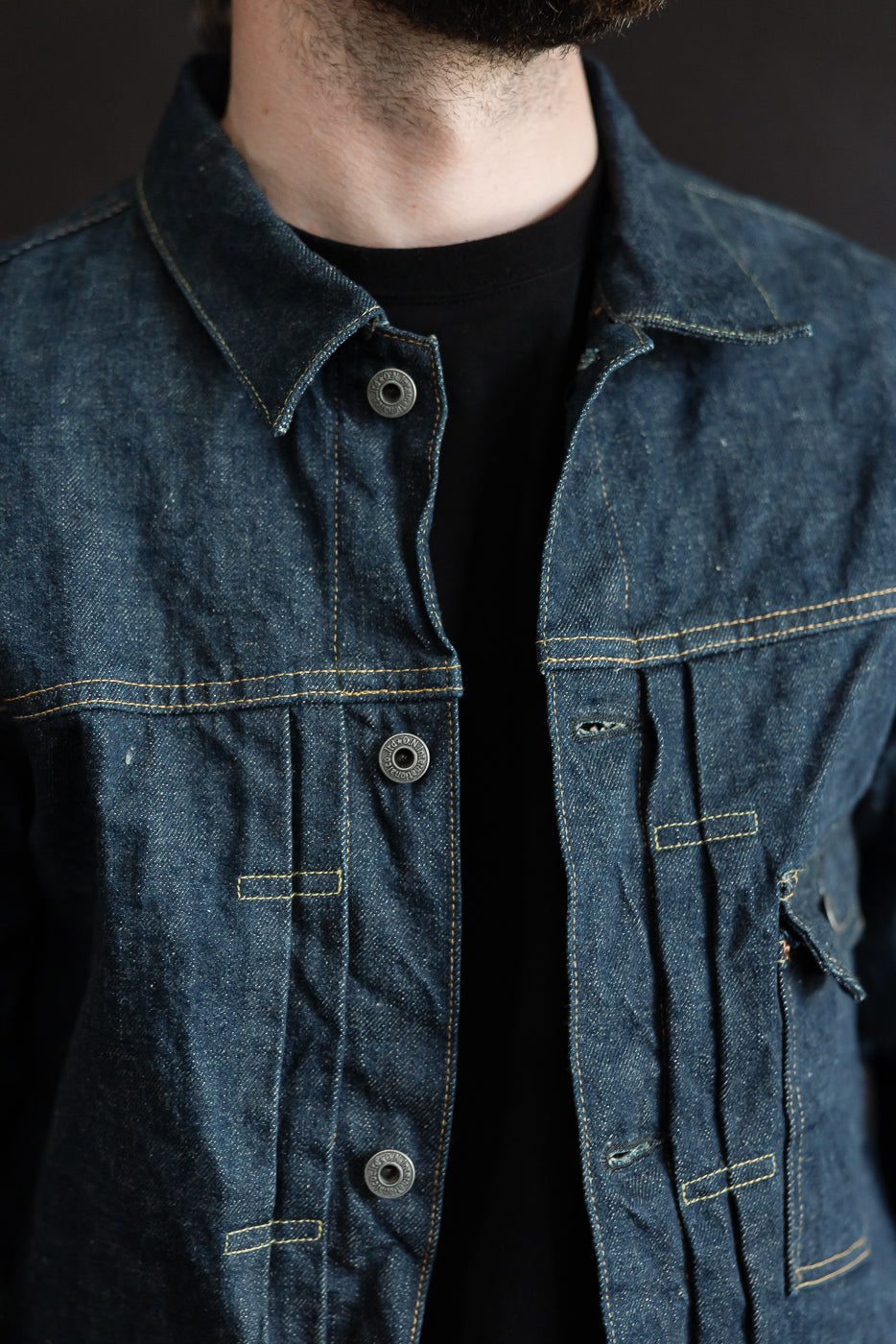 Close-up front view of 15oz selvedge denim jacket worn by male model 5'9