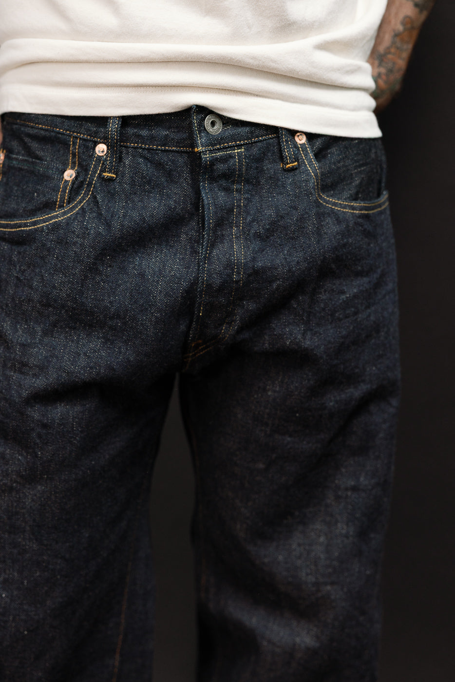 Front close-up of dark selvedge jeans on male model, 5'9