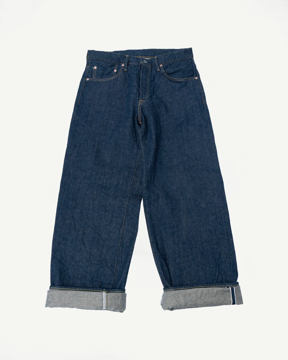 Flat lay, front view of wide straight selvedge denim jeans with cuffed hems, no model.